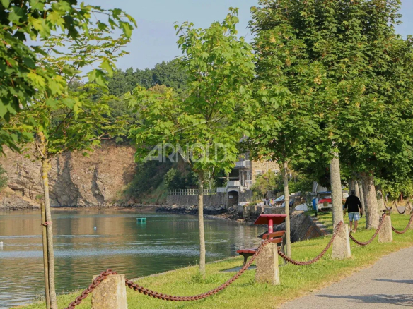 View of the banks of the Rance at Saint-Suliac with trees and a path along the water.