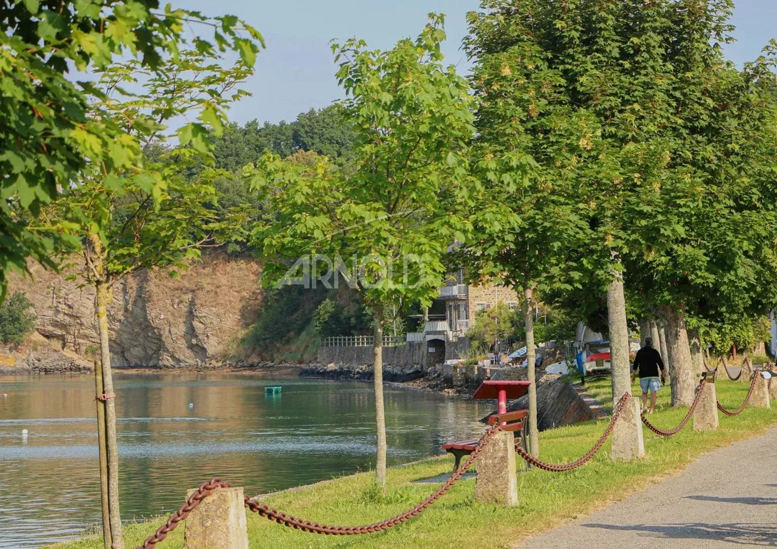 View of the banks of the Rance at Saint-Suliac with trees and a path along the water.