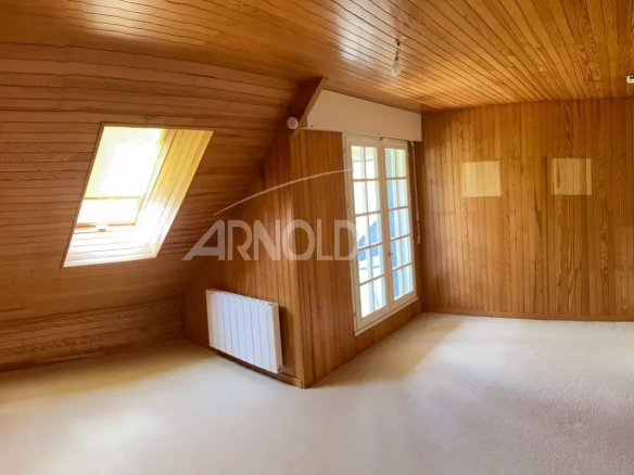 Intérieur d'une maison néo-bretonne à Vannes, avec des murs en bois et une fenêtre donnant sur l'extérieur.