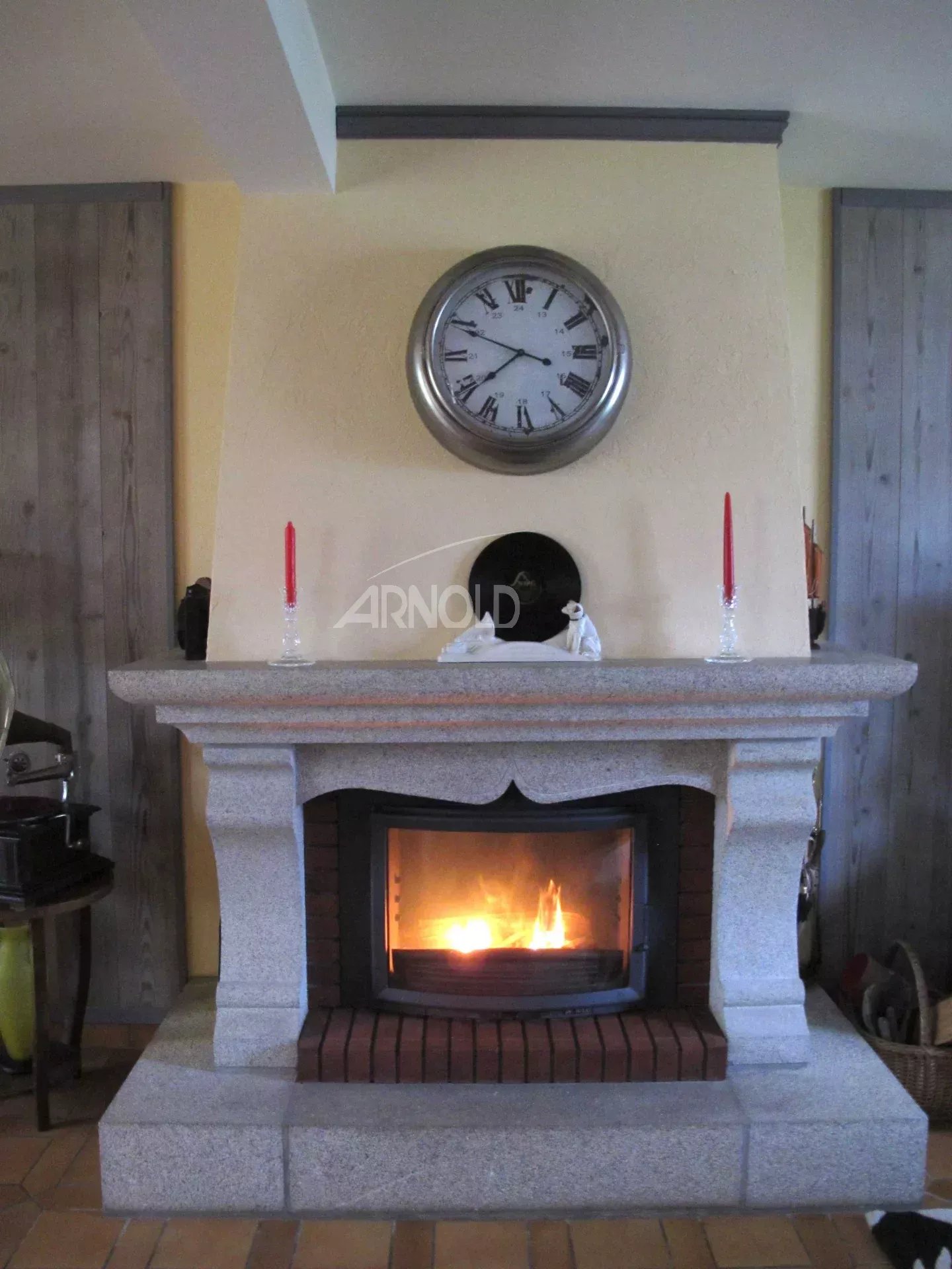 Cheminée en pierre avec horloge et bougies, intérieur d'une maison néo-bretonne à Vannes.