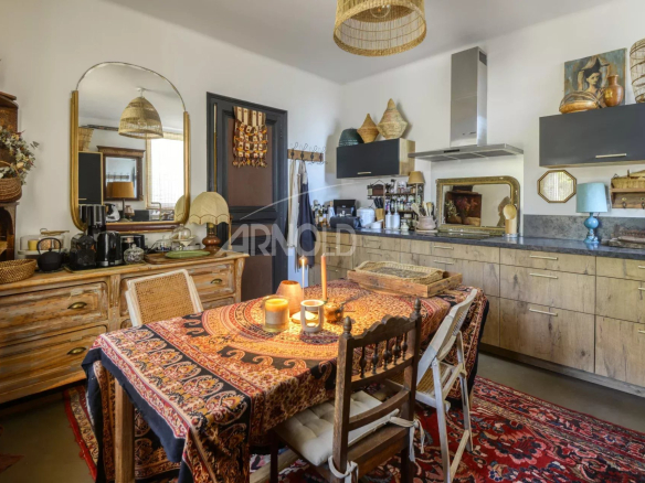 Cuisine chaleureuse avec table en bois et décoration authentique dans une maison à Saint-Étienne-de-Montluc.