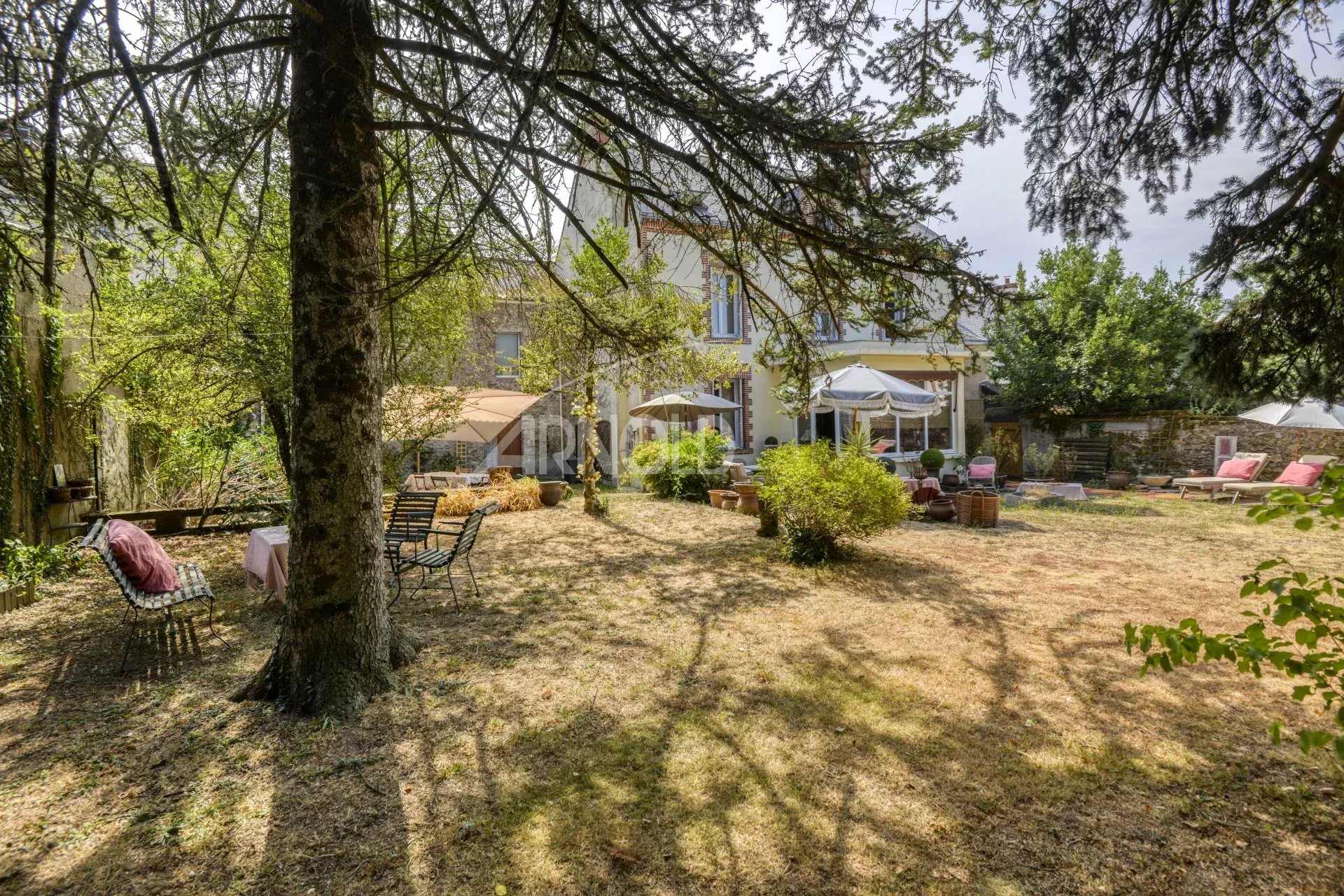 Maison de charme à Saint-Étienne-de-Montluc Jardin d'une maison bourgeoise à Saint-Étienne-de-Montluc avec chaises et parasols.