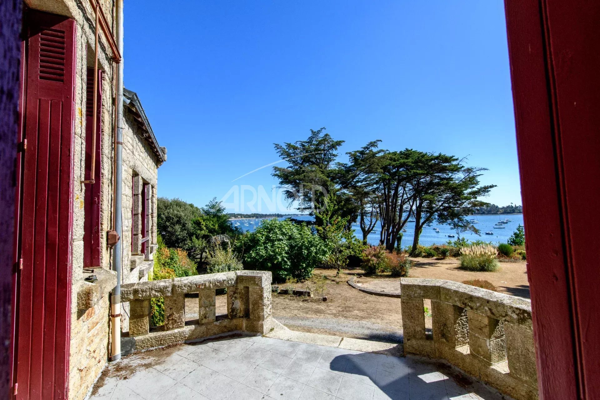 Propriété avec vue sur le Golfe du Morbihan Terrasse d'une propriété avec vue sur le Golfe du Morbihan, entourée de verdure.