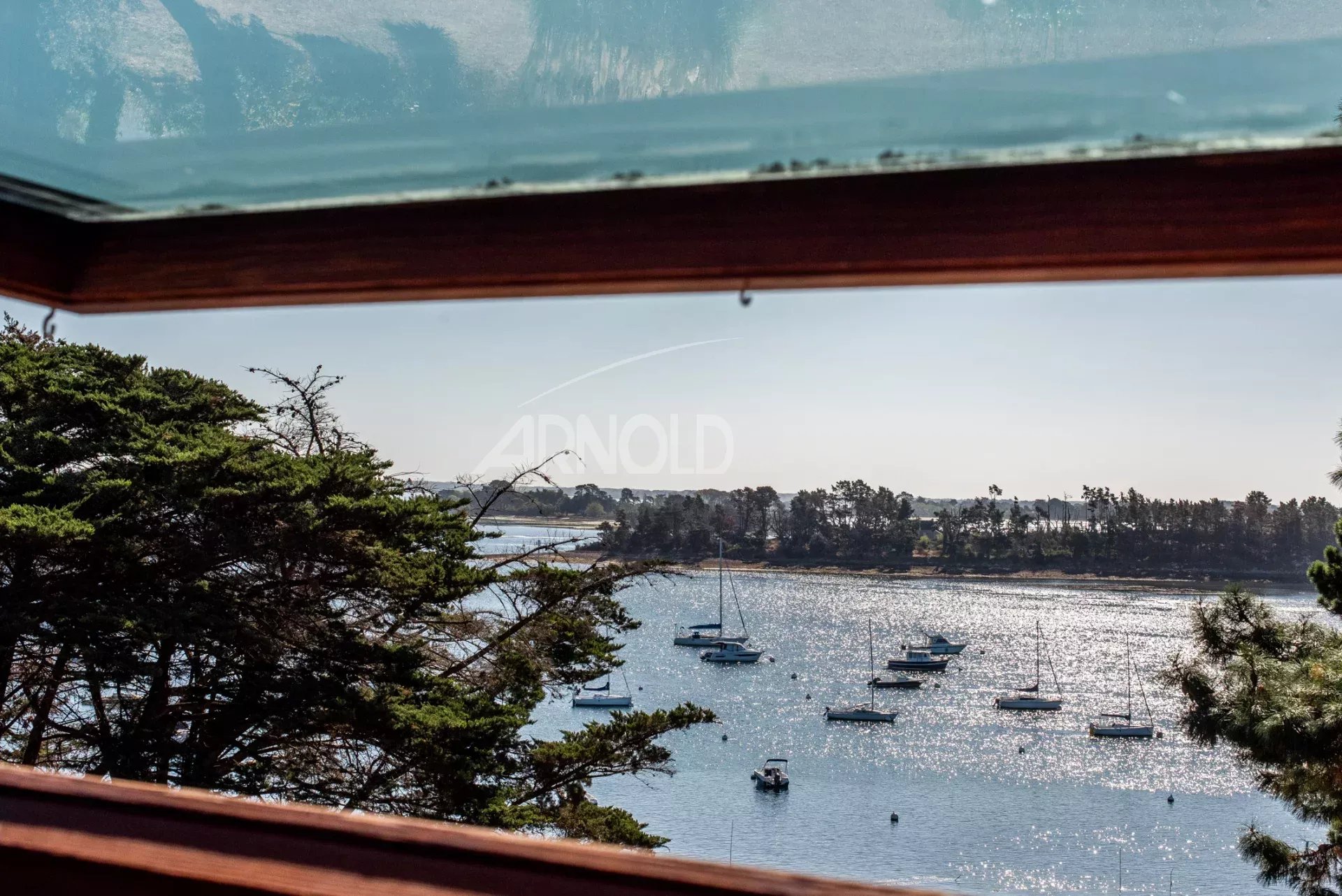 Vue sur le Golfe du Morbihan Vue panoramique sur le Golfe du Morbihan depuis une terrasse avec des bateaux au loin.