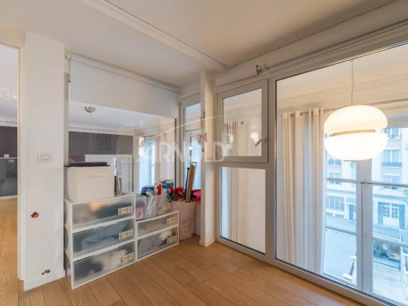 Intérieur d'un duplex lumineux avec grandes fenêtres et espace de vie spacieux.