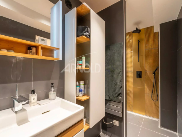 Salle de bain moderne avec douche et lavabo dans un duplex à Paris 9.