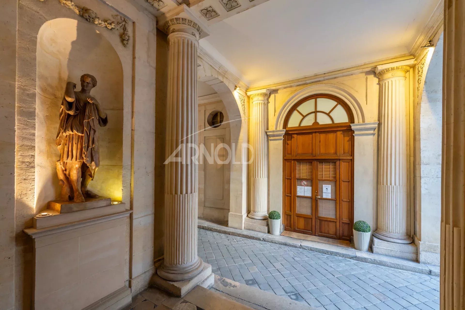 Entrée d’un hôtel particulier à Paris 9ème Entrée d'un hôtel particulier à Paris 9ème avec colonnes et porte en bois
