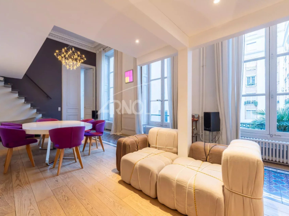 Intérieur d'un duplex lumineux avec salon et salle à manger, hôtel particulier à Paris 9ème.