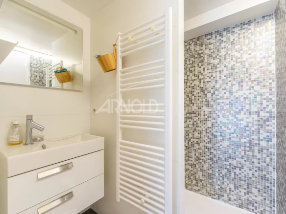 Salle de bain moderne avec douche et miroir, appartement en duplex à Paris 9ème.