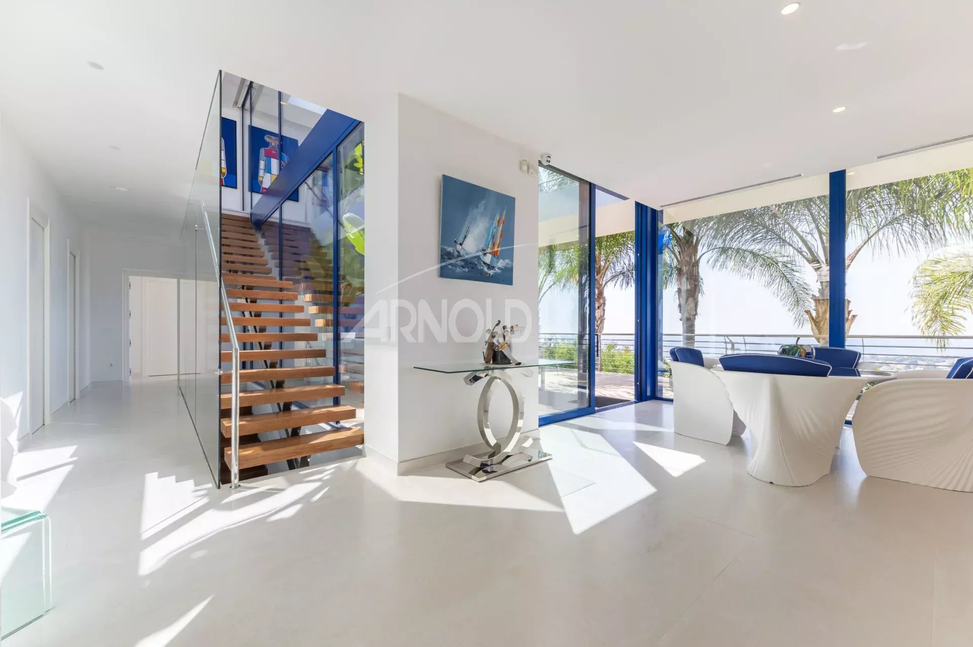 Modern interior of a villa with sea views in Calpe, panoramic windows and a wooden staircase.