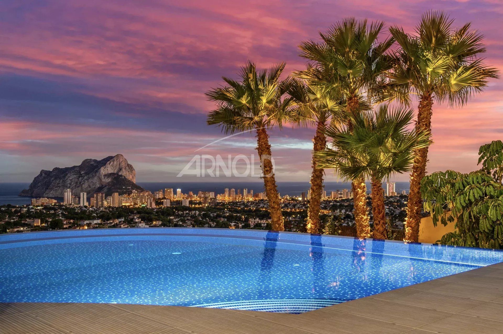 Modern villa with infinity pool and sea view in Calpe, Spain, at sunset.