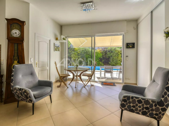 Intérieur d'une maison moderne avec salon et salle à manger, vue sur la piscine