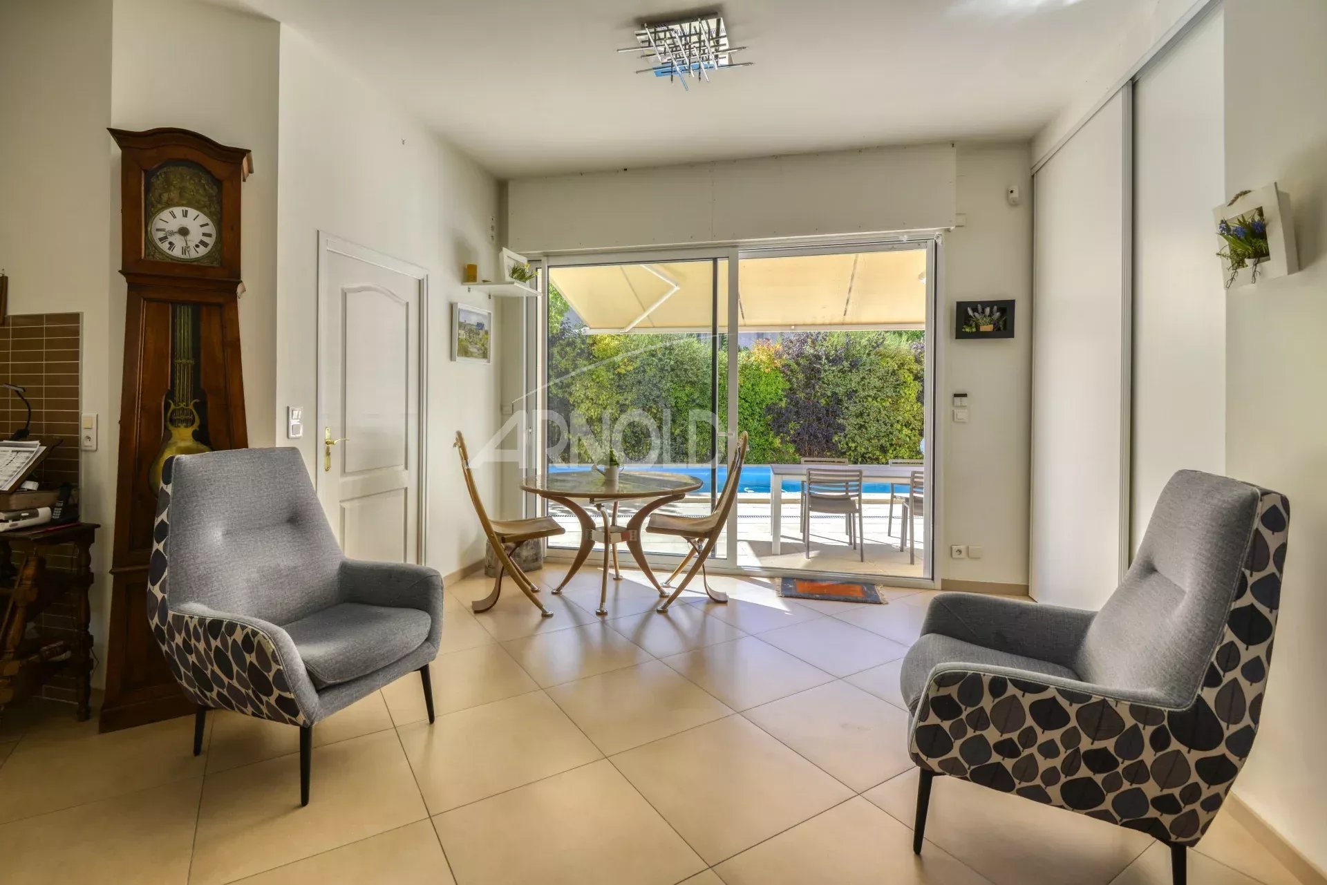 Intérieur d'une maison moderne avec salon et salle à manger, vue sur la piscine