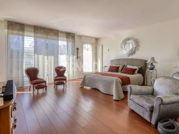 Chambre spacieuse avec parquet, fauteuils et décoration élégante dans une maison à Nantes.