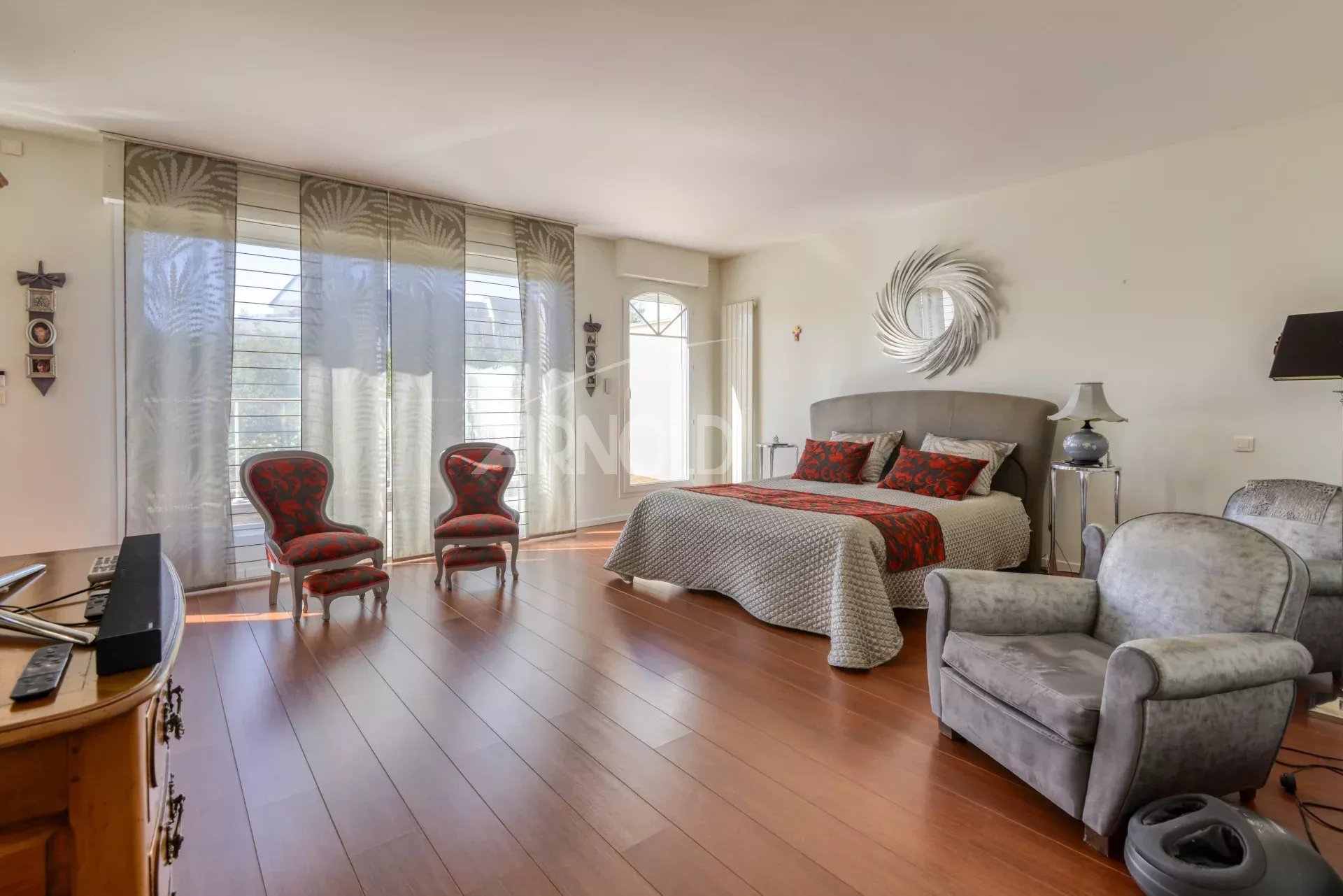 Chambre spacieuse avec parquet, fauteuils et décoration élégante dans une maison à Nantes.