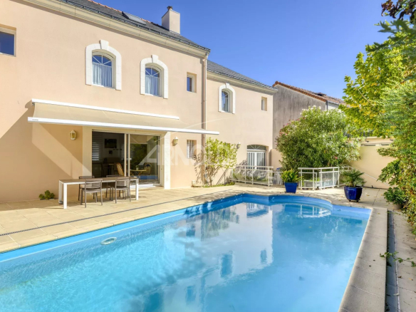 Maison de standing avec piscine dans une impasse privée à Nantes, entourée de verdure.