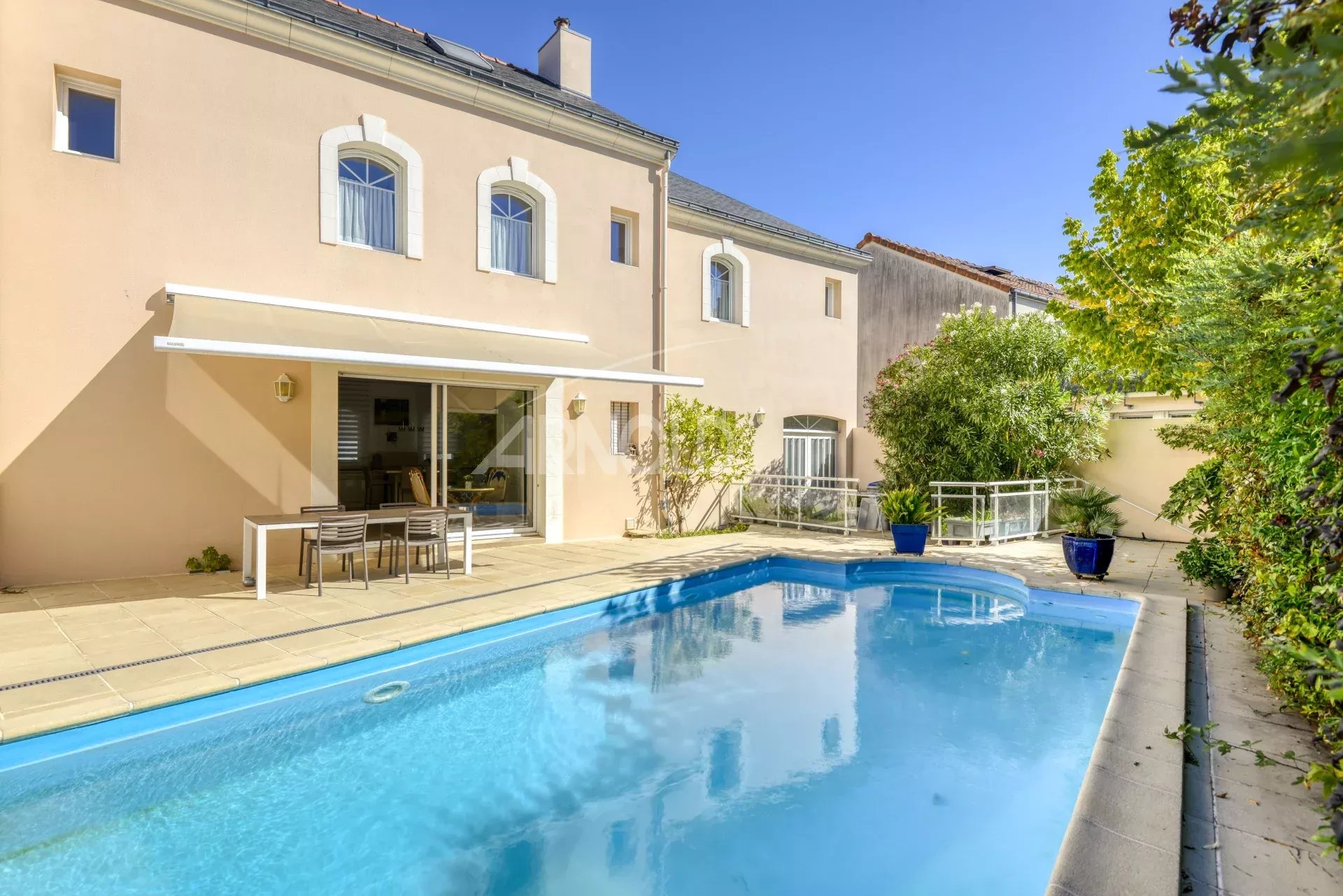 Maison de standing avec piscine dans une impasse privée à Nantes, entourée de verdure.