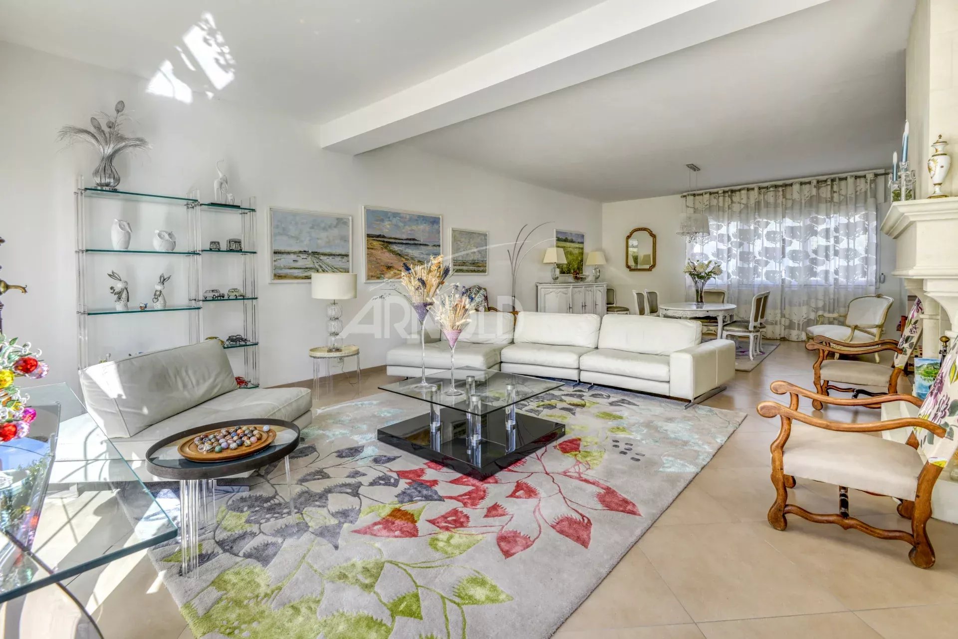 Intérieur d'une maison moderne avec salon lumineux, cheminée et salle à manger.