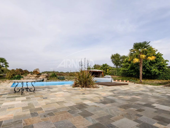 Stone terrace with swimming pool and greenery, contemporary house in Surzur