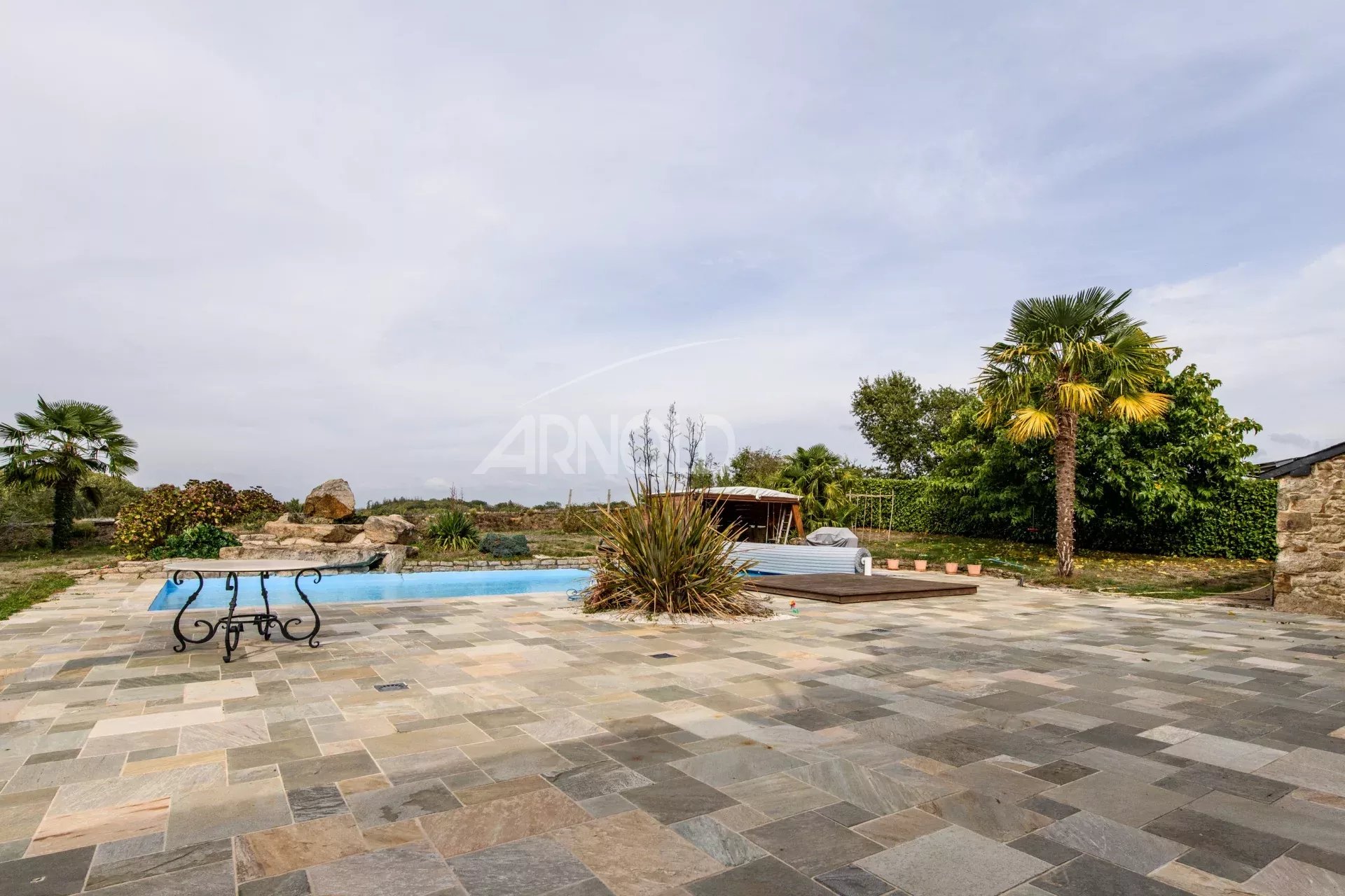 Contemporary farmhouse with swimming pool Stone terrace with swimming pool and greenery, contemporary house in Surzur