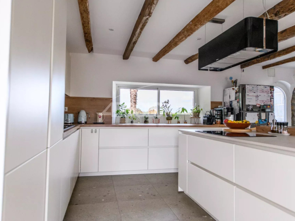 Modern and bright kitchen with exposed beams and a view of the outside.
