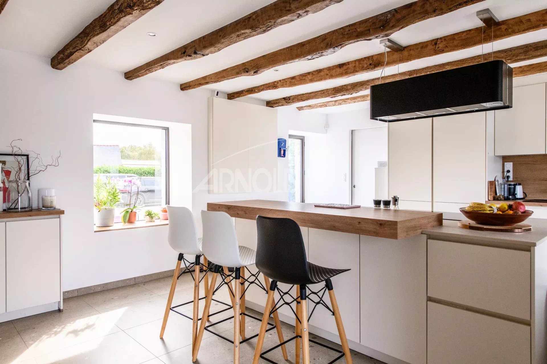 Contemporary kitchen with bar Modern kitchen with bar and high chairs, exposed beams, natural light.