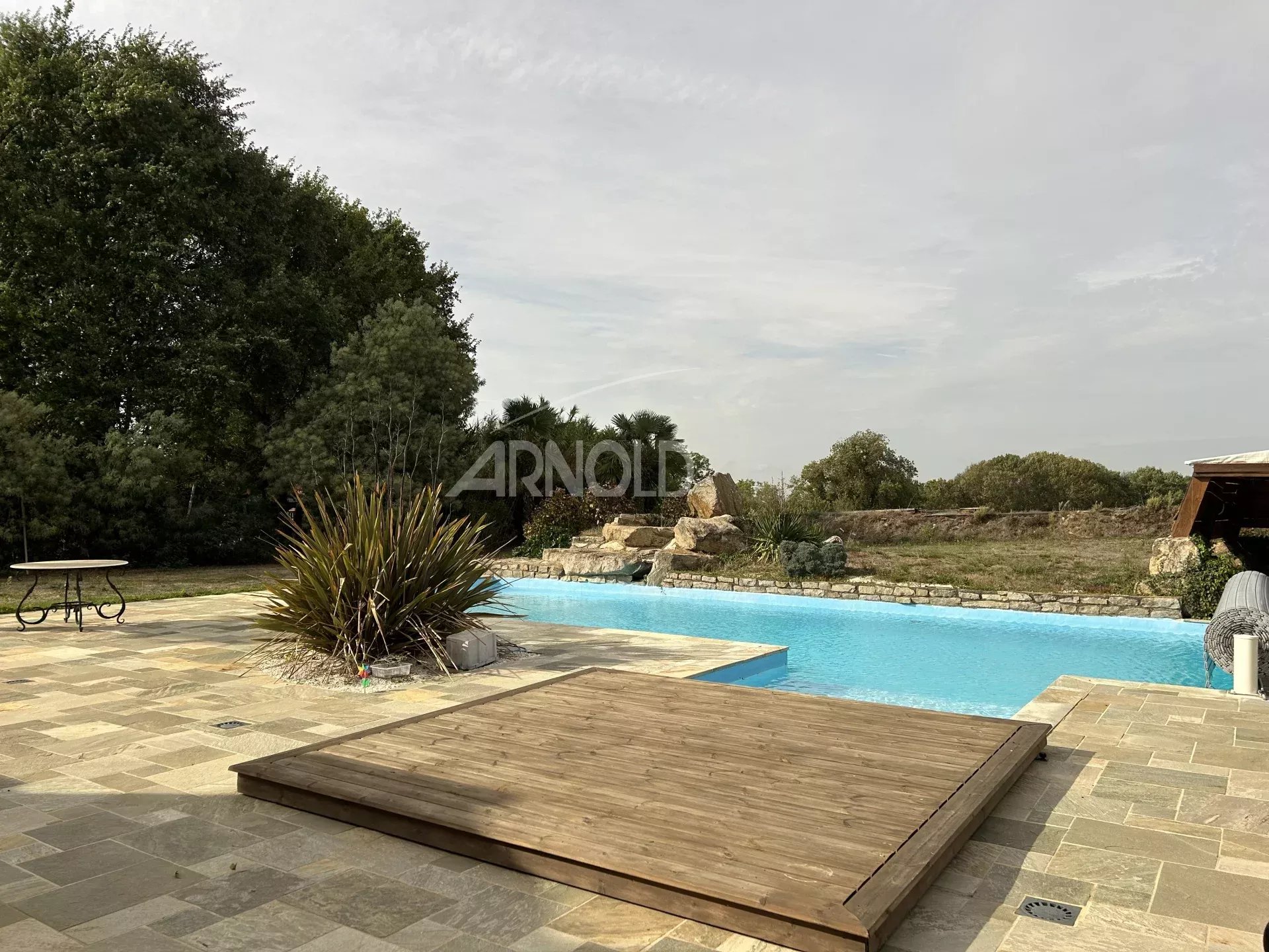 Contemporary farmhouse with swimming pool Stone terrace with swimming pool and vegetation, contemporary house in Surzur.