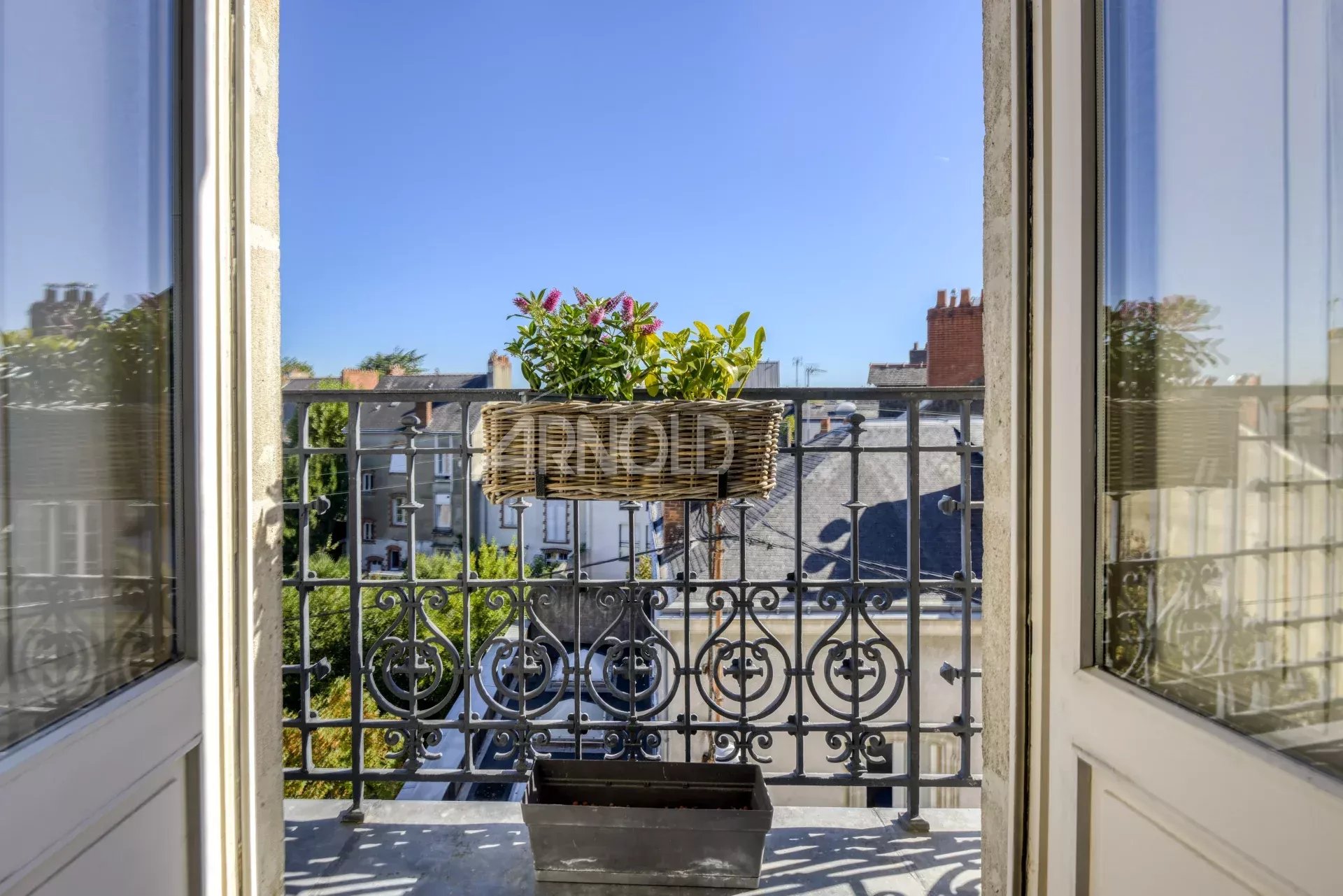 Balcony of an apartment in Nantes Balcony overlooking a private passage in Nantes, flowers and a terracotta pot on the balustrade.