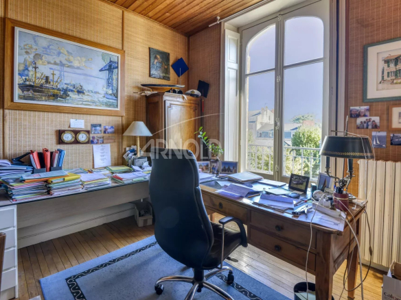 Bright office with a wooden desk and windows overlooking a private passage in Nantes.
