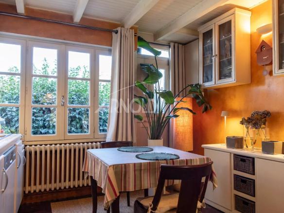 Intérieur d'une cuisine chaleureuse avec table à manger et plantes, maison à Belz.