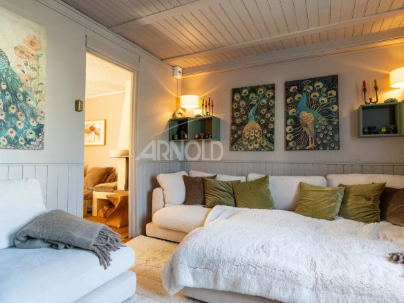 Intérieur d'une maison de charme à Belz avec un salon confortable et des œuvres d'art murales.