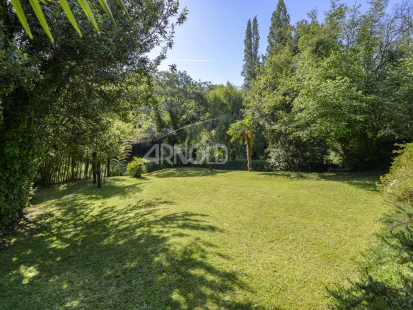 Jardin verdoyant d'une propriété au Pellerin avec pelouse et arbres