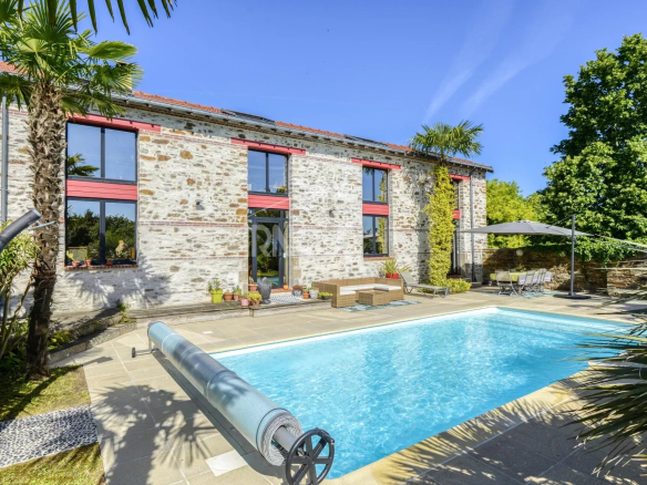 Propriété rénovée avec piscine et jardin à Le Pellerin, vue sur façade en pierre.