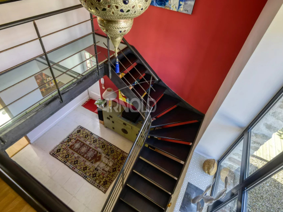 Escalier moderne avec rampe en verre et tapis au sol dans une propriété rénovée au Pellerin.