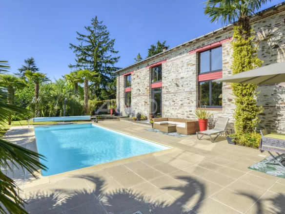 Propriété avec piscine entourée de végétation à Le Pellerin, ensoleillée et calme.