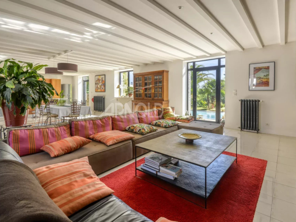 Intérieur d'une propriété moderne avec un salon spacieux, canapé et table basse, éclairé par de grandes fenêtres.