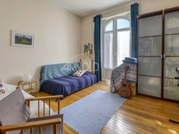 Intérieur d'un appartement T6 avec un canapé, un bureau et un parquet en bois à Nantes.