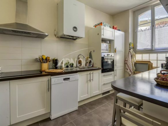 Cuisine moderne dans un appartement T6 à Nantes, avec équipements intégrés et plan de travail en bois.