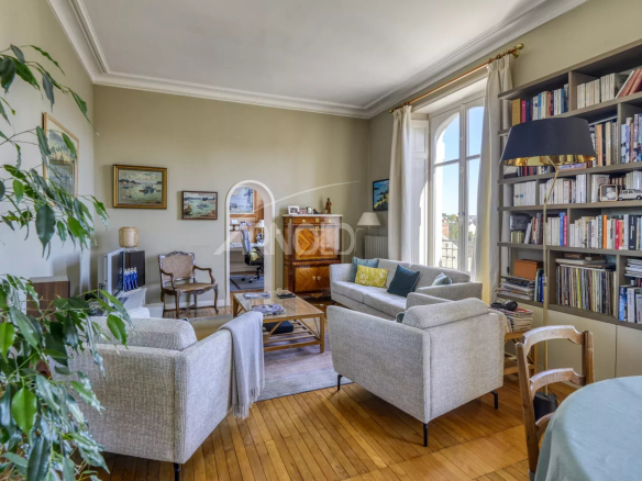 Salon lumineux d'un appartement T6 avec des meubles modernes et une bibliothèque, situé à Nantes.