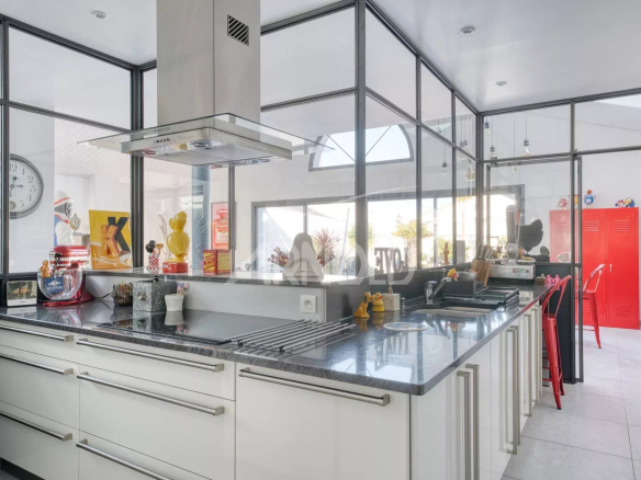 Cuisine moderne et lumineuse d'une villa contemporaine avec îlot central et équipements haut de gamme.