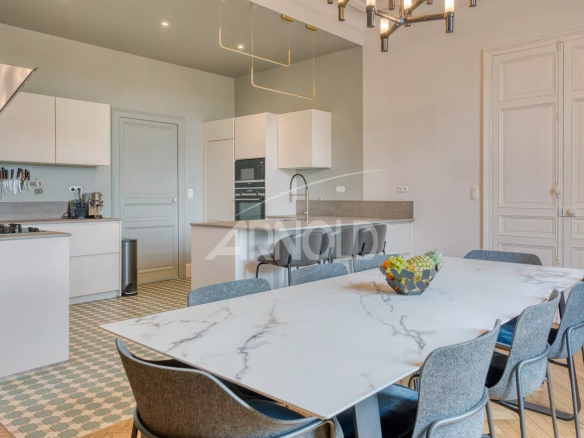 Interior of a modern kitchen with a large dining table and contemporary furniture.