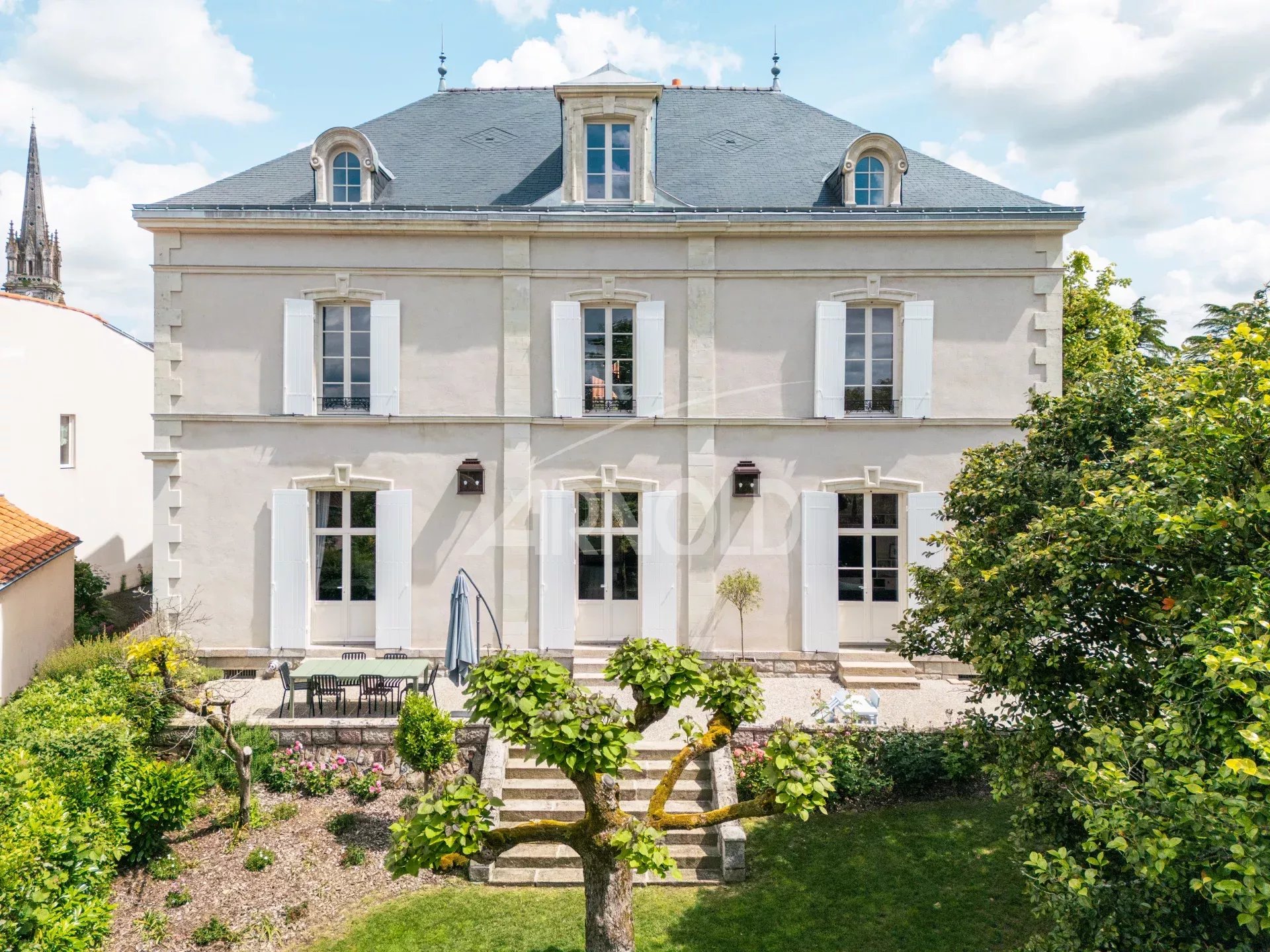 18th century priory with garden in Rocheservière, elegant facade and white windows.