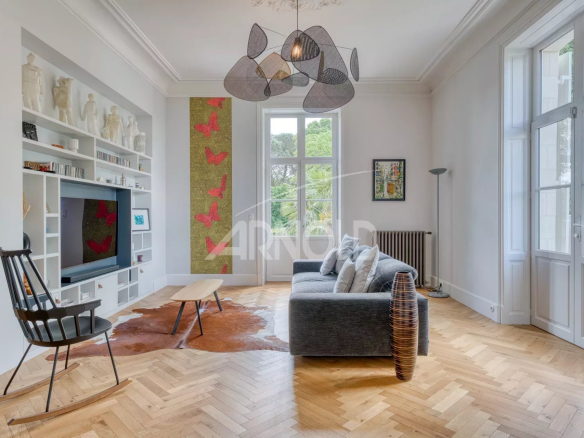 Interior of a bright living room with a sofa, a television and wall decorations.