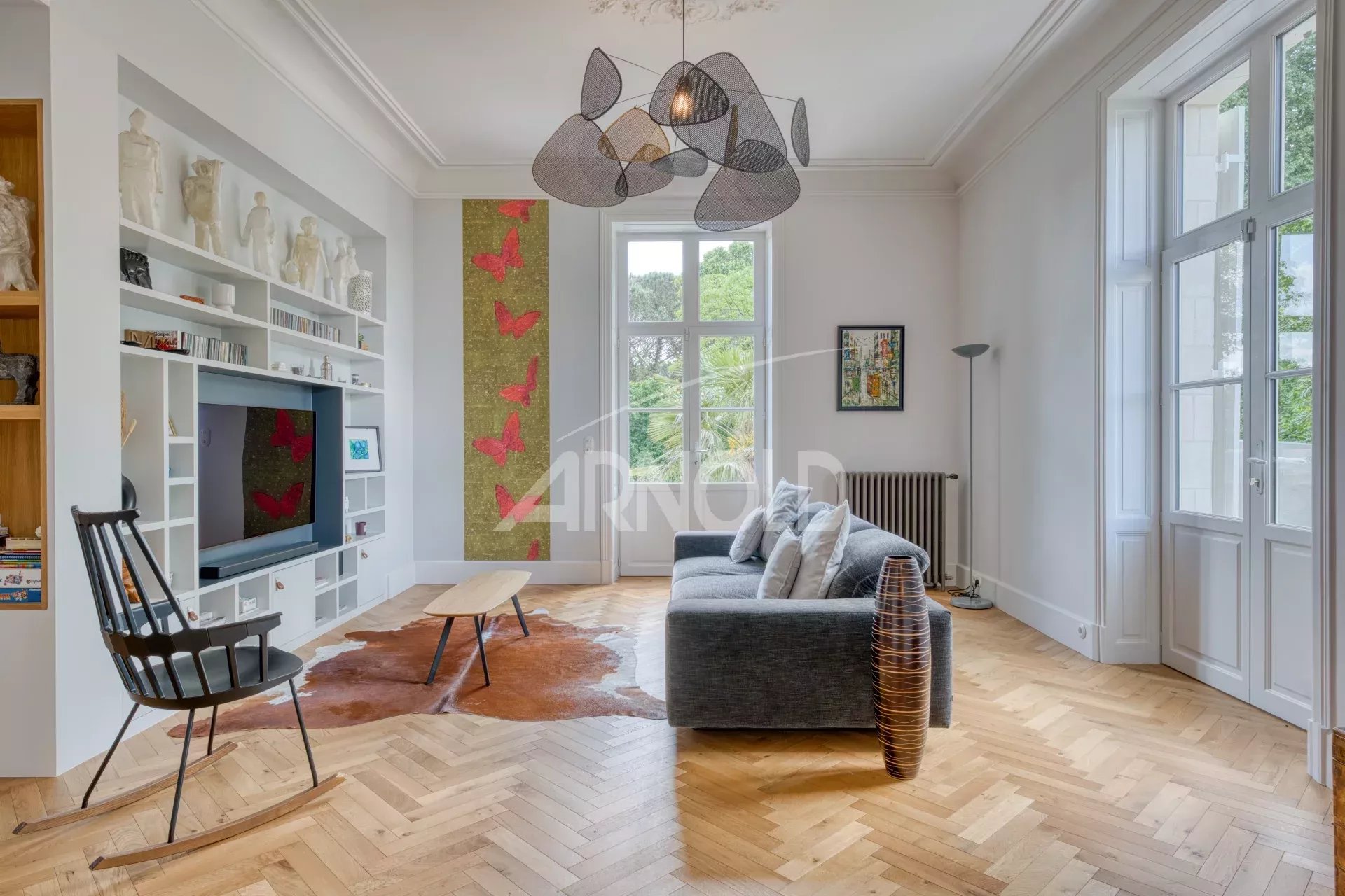 Interior of a bright living room with a sofa, a television and wall decorations.