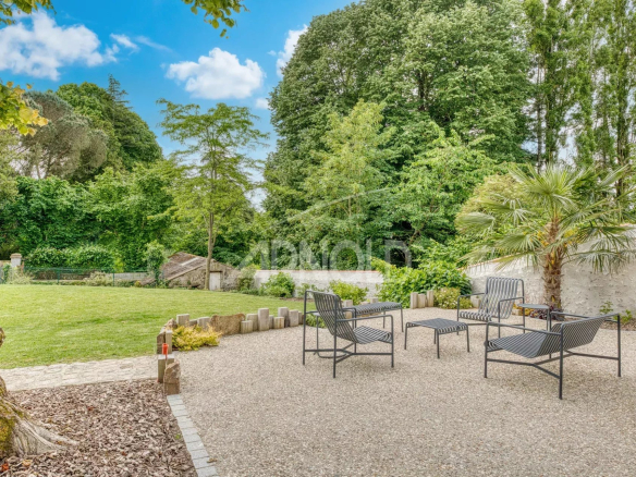 Outdoor space of a property with chairs and a green garden.