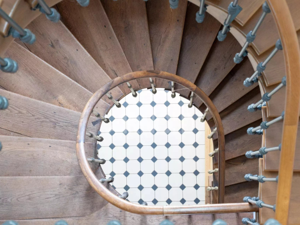 Wooden spiral staircase with metal railing in an 18th century property.