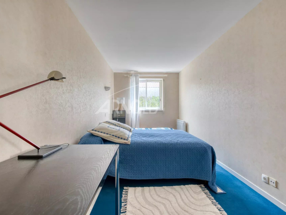 Spacious room with bed and simple decor in a house in Saint-Gilles-Croix-de-Vie.