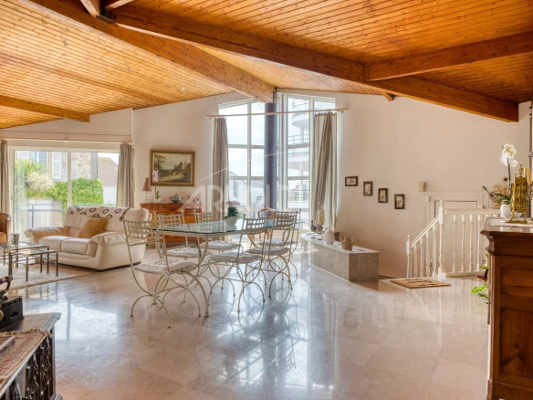 Interior of a spacious house with a bright living room and dining room, tastefully decorated.