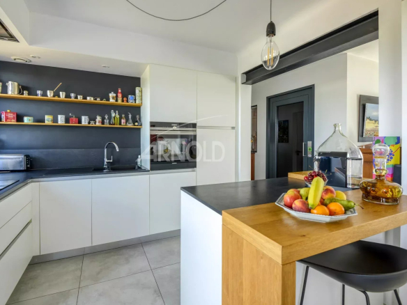 Modern and bright kitchen with central island, view of shelves and equipment.