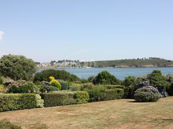Vue panoramique sur l'océan et la plage depuis un jardin paysagé à Arzon.